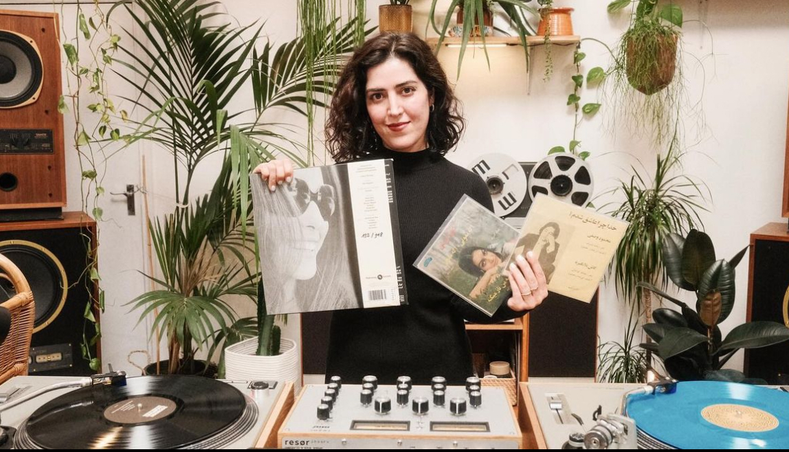 A photo of Katayoun holding some records into the camera